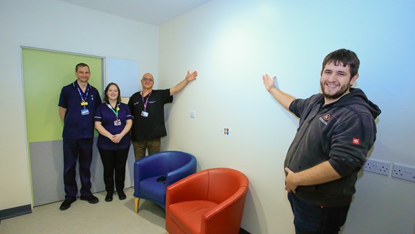 Pictured with the blank wall in the ED treatment room are, left to right: Hereford Mental Health Liaison Team Clinical Lead for Herefordshire and Worcestershire Health and Care NHS Trust, James, ED Sister Pippa, ED Consultant Cat and Ryan Midgley, from SignWorx.